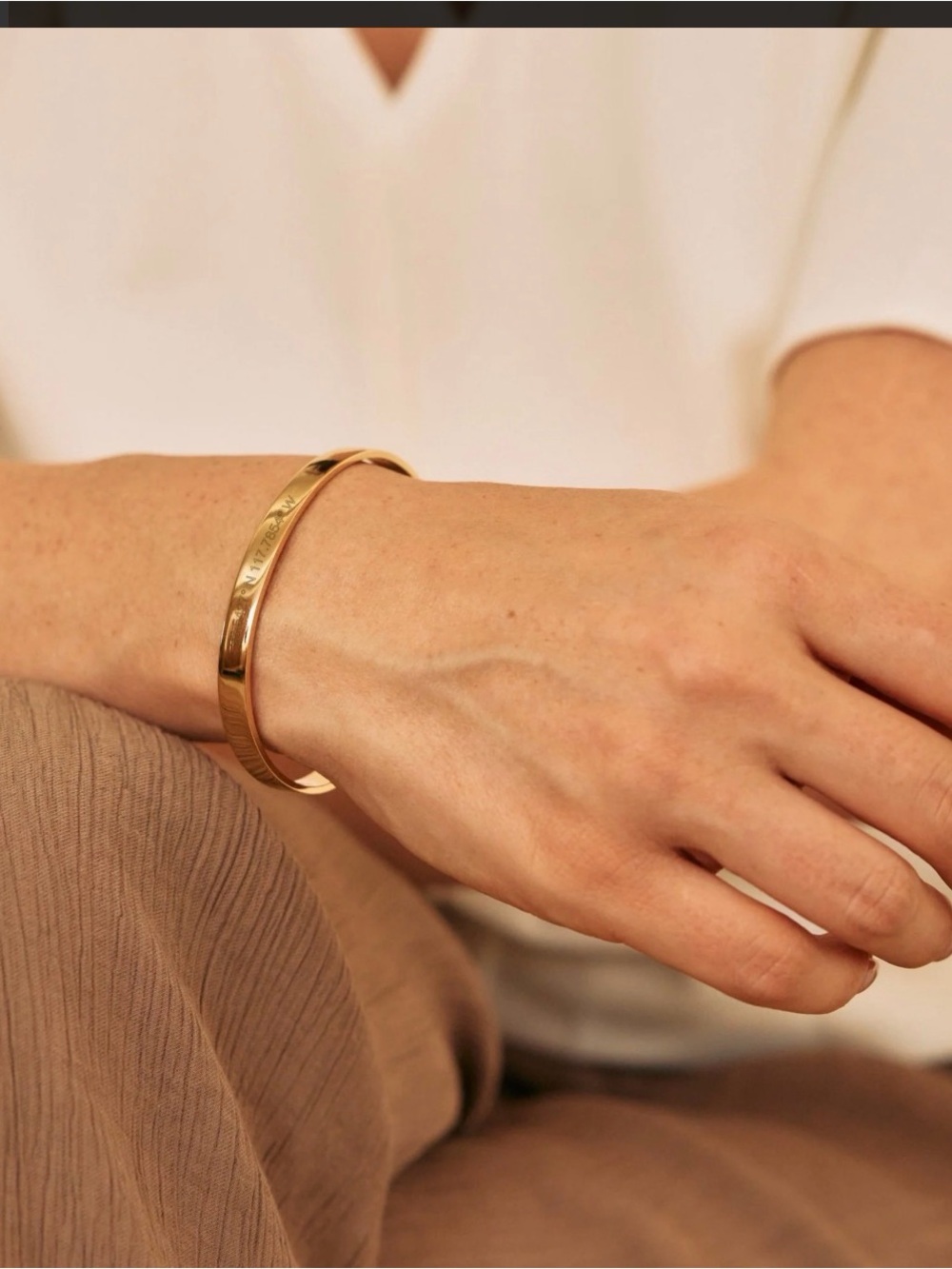 Time squareCoordinates engraved gold cuff bracelet points directly at time squar